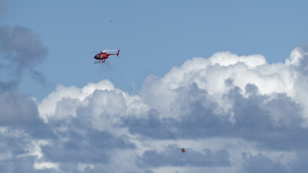 Un hélicoptère qui tire une poche à eau contre les incendies